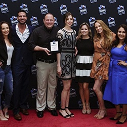 Snow Dental team at event with dentist holding a plaque