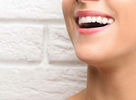 Close up of smiling woman in front of brick wall