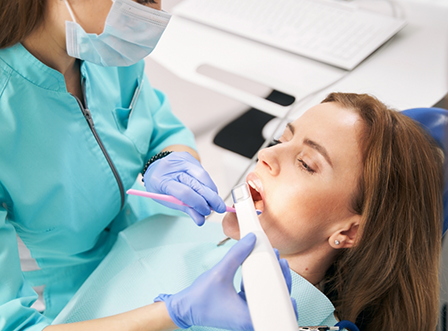 Female patient having teeth digitally scanned