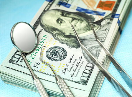 Dental instruments lying on top of hundred dollar bills