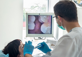 Examining patient's teeth with intraoral camera