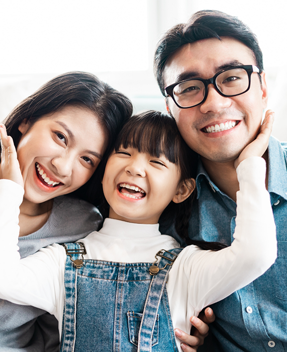 Little girl between her parents smiling