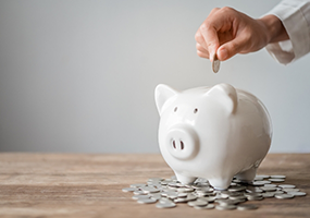 Putting coin in piggy bank