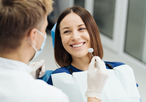 Female patient having teeth examined by dental mirror