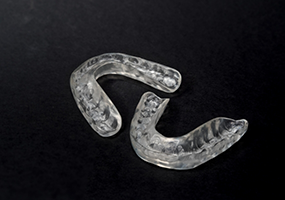 Two nightguards on a black surface