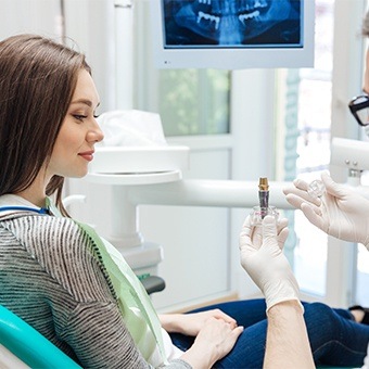 Man showing a dental patient a dental implant model