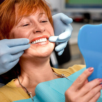 woman smiling while visiting dentist for checkup