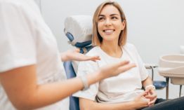Female patient in dental chair smiling at dentist