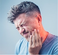 Man holding his cheek in pain