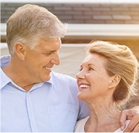 Older man and woman smiling at each other outdoors
