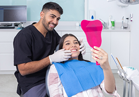 Dentist holding patient's mouth open while they check their smile