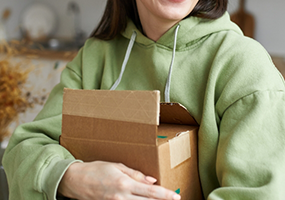 Woman in green hoodie with an open package