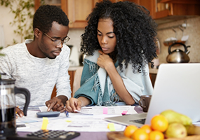Man and woman looking at papers on busy table