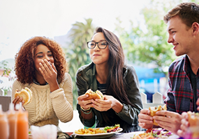 Group of people enjoying meal at picnic table