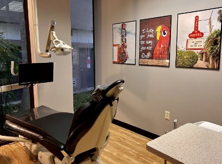 Treatment room with dental chair and pictures on wall