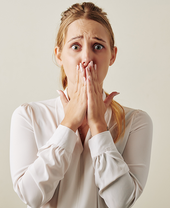 Woman in white shirt covering her mouth