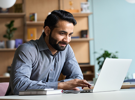 Bearded man typing on laptop