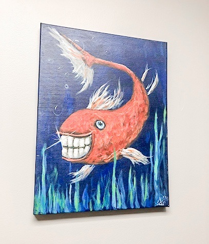 Large painting of a smiling red fish with sparkling teeth