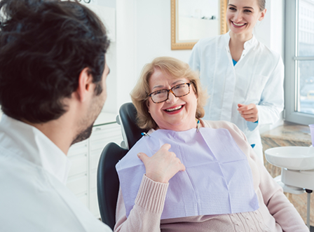 Female dental patient laughing and talking with dentists