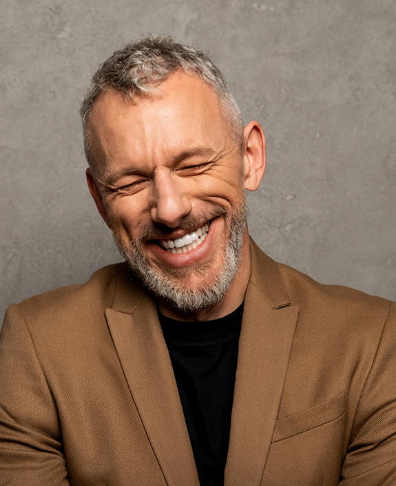 Smiling man in brown jacket