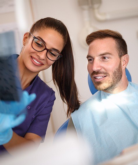 Dental team member and patient looking at dental x rays with advanced dental technology in Austin