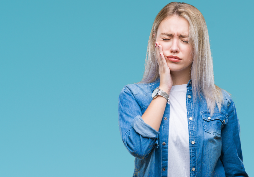 Woman holding jaw and wincing